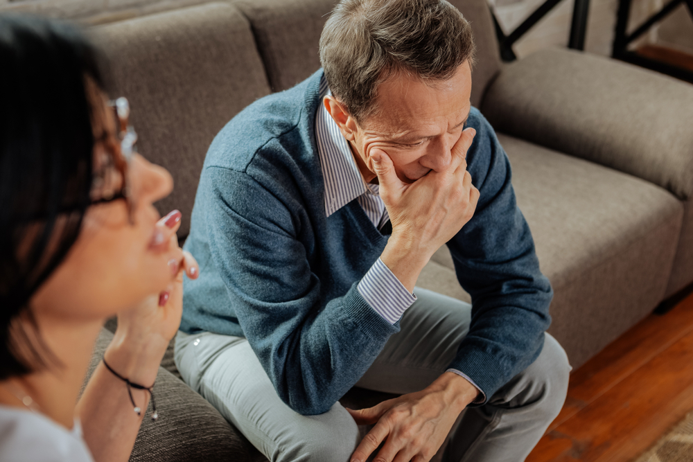 Supportive Female Doctor talking with Distressed Man